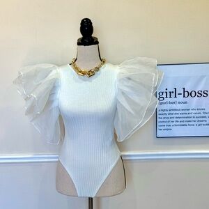 White bodysuit with sheer puff sleeves.